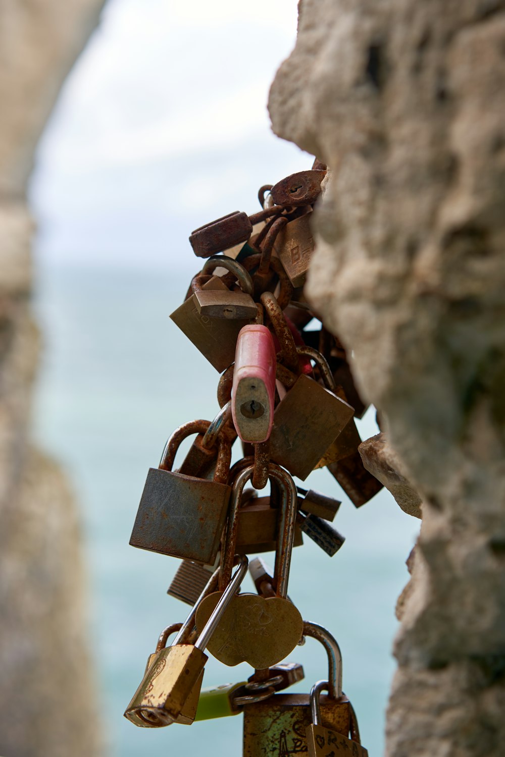 a bunch of padlocks attached to a rock