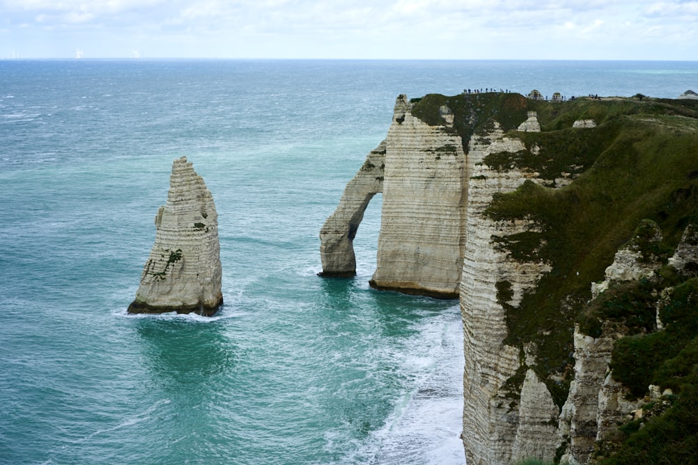 a large body of water next to a rocky cliff