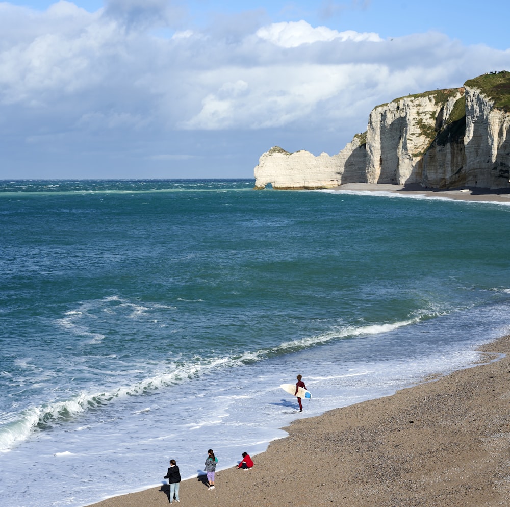 a group of people standing on top of a sandy beach