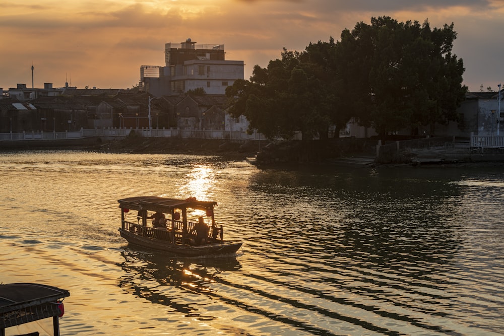 a boat traveling down a river at sunset