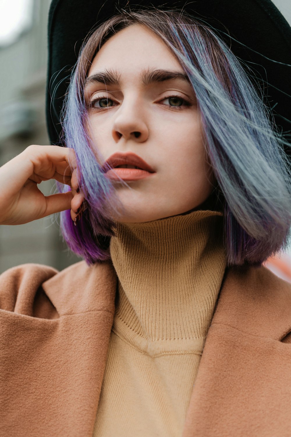 a woman with purple hair and a black hat