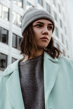 a woman in a blue coat and a gray hat