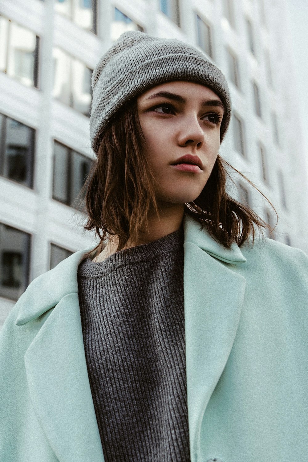 una donna con un cappotto blu e un cappello grigio