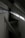Concrete beams intersect at various angles within a minimalist, industrial space. Natural light filters through a row of windows, casting geometric shadows on the walls.
