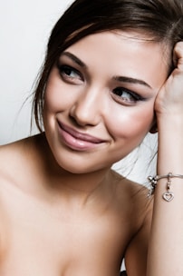 a beautiful young woman wearing a bracelet and smiling