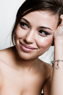 a beautiful young woman wearing a bracelet and smiling