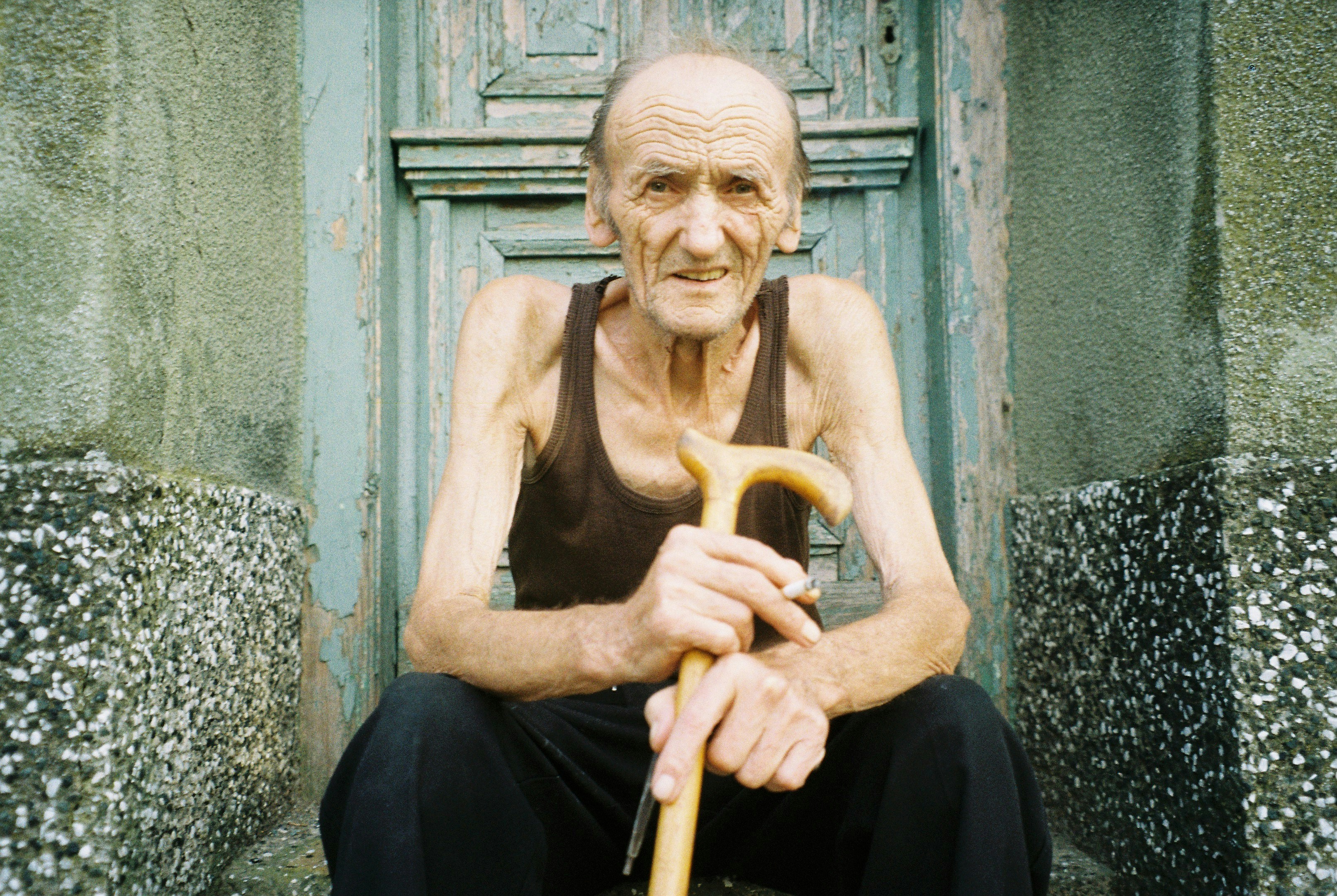 a man sitting on a bench holding an umbrella