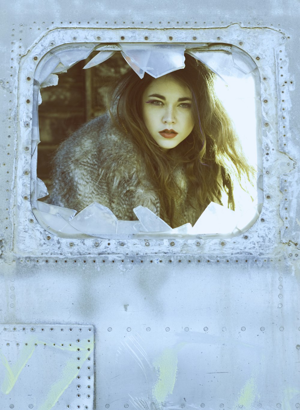 a woman with long hair looking out of a window