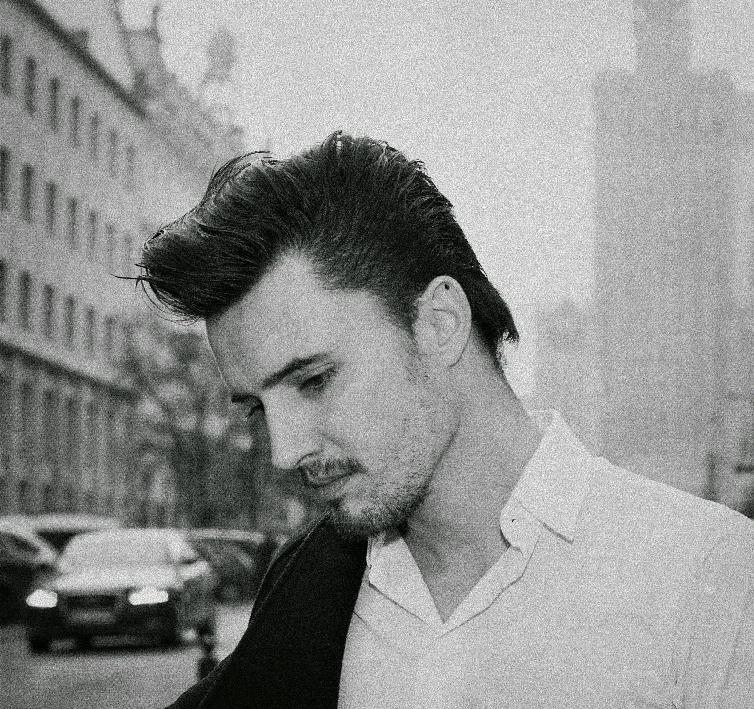 a man in a white shirt is standing on the street