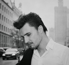 a man in a white shirt is standing on the street