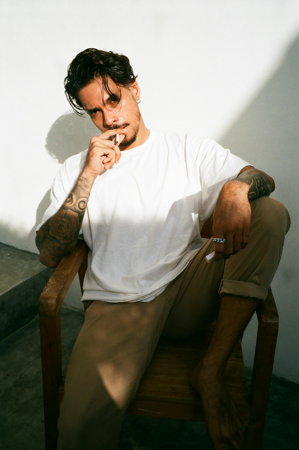 a man sitting in a chair smoking a cigarette