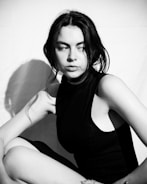 Artistic portrait of a woman with dramatic shadows and a vintage backdrop.