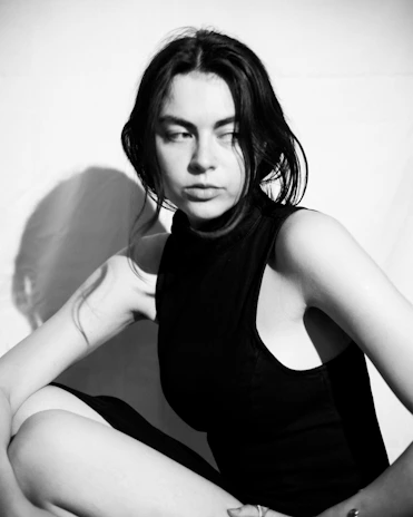A refined portrait of a model in a deep onyx black dress, framed by delicate shadows.