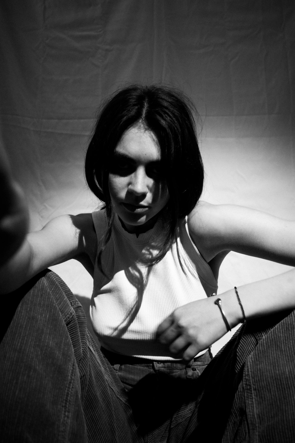 a black and white photo of a woman sitting on the ground