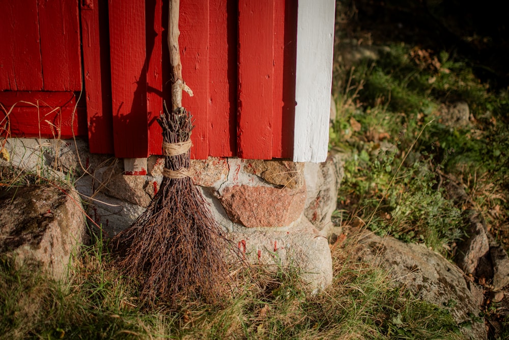 a broom leaning up against a red wall