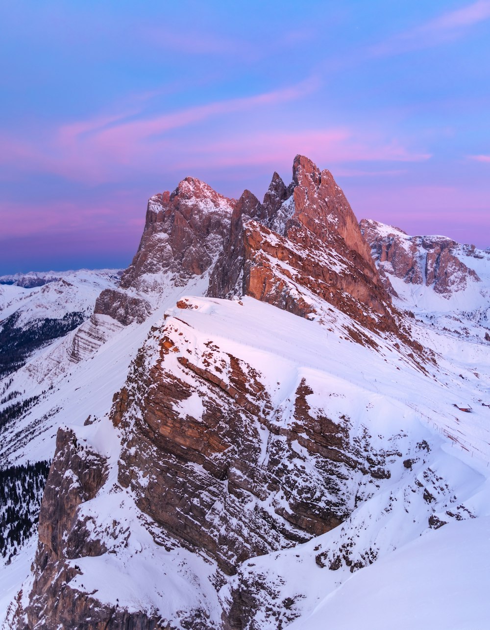 a snow covered mountain with a pink sky in the background