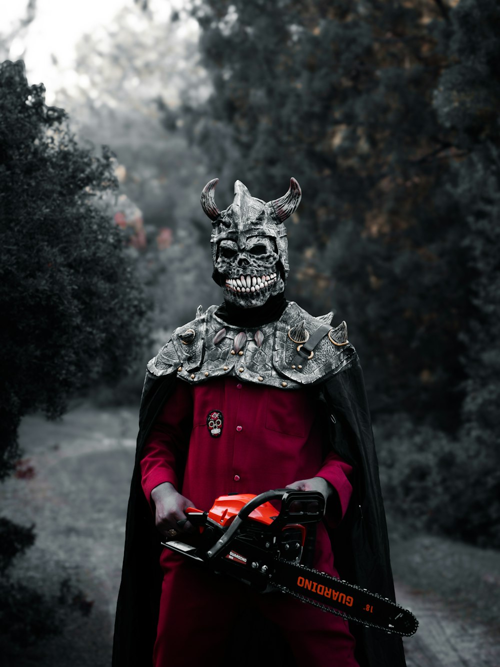 a man in a devil mask holding a chainsaw