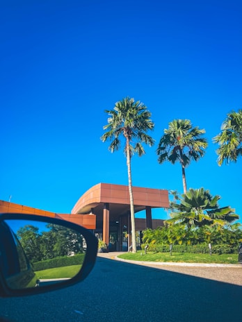 A sleek modern office building in Bali showcasing clean lines and tropical landscaping under a bright blue sky.