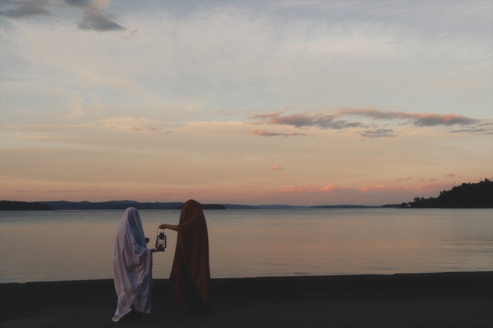 a couple of women standing next to each other near a body of water