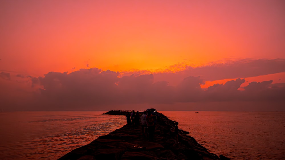 a group of people standing on top of a pier