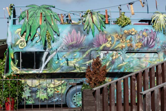 A vibrant city bus in Málaga wrapped with colorful advertising graphics