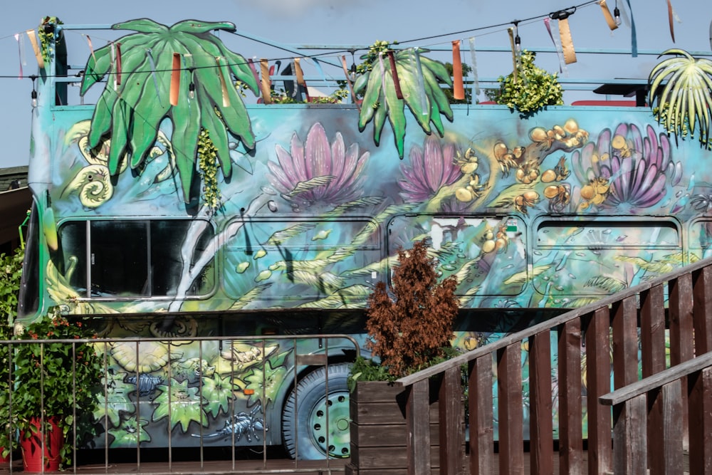 a bus painted with flowers and plants on the side