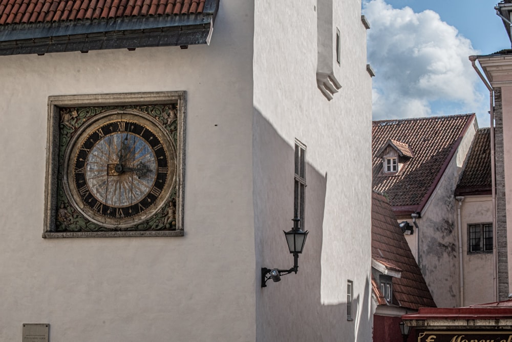 a clock mounted to the side of a white building