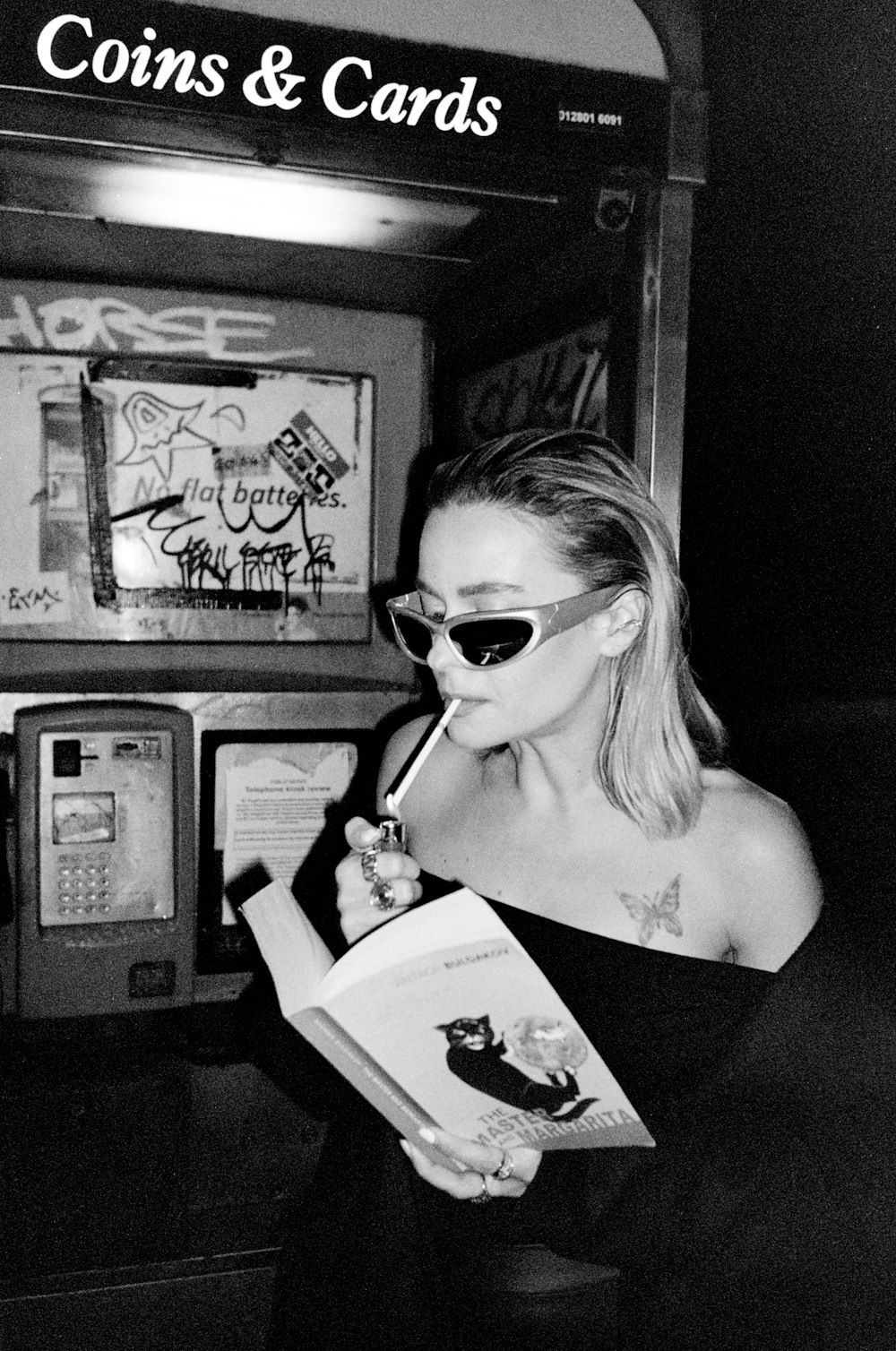 a woman in a black dress is holding a book