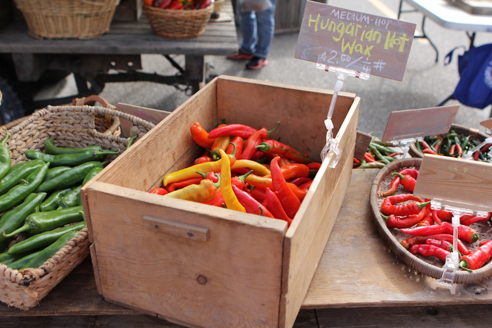 a wooden box filled with lots of red and green peppers