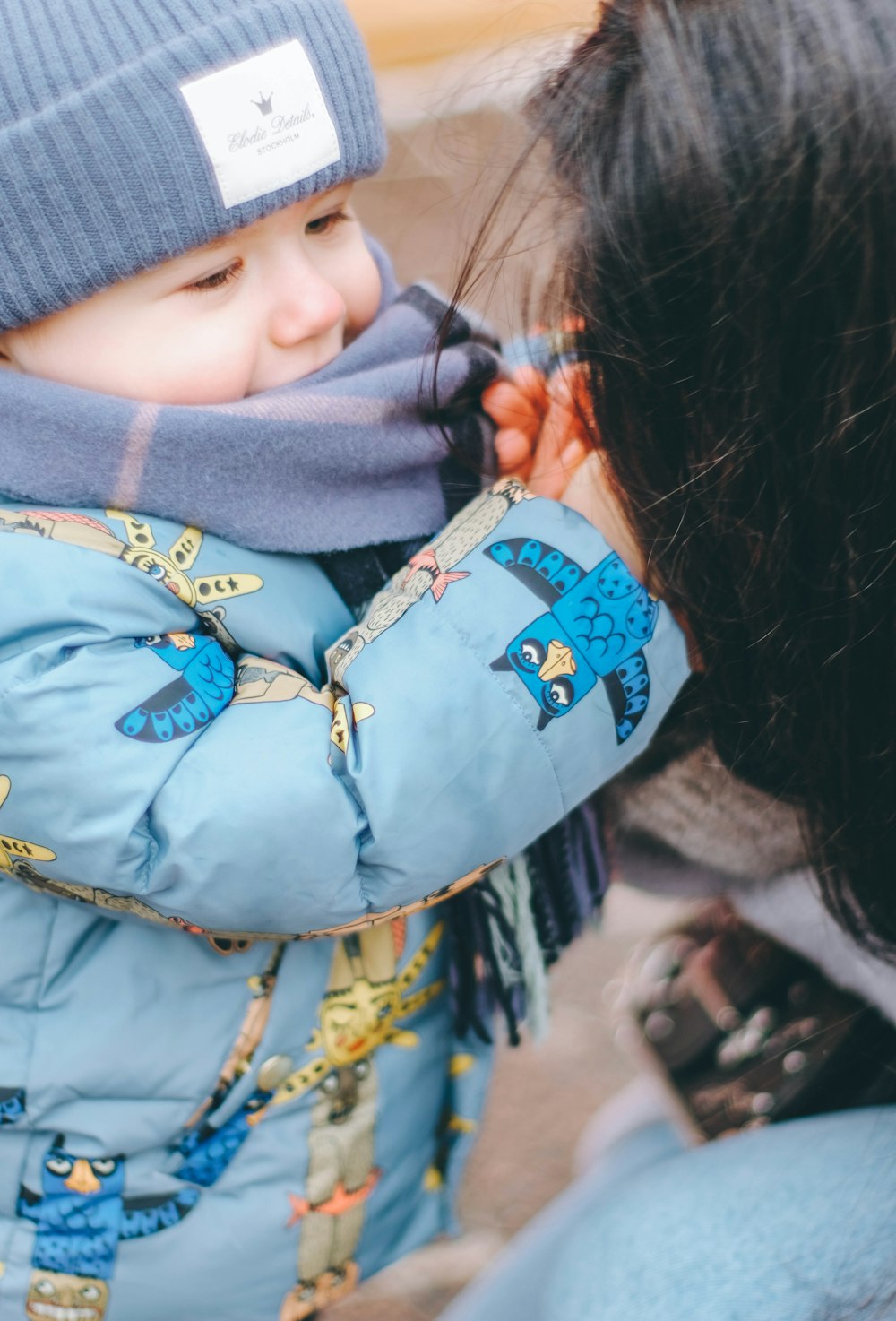 a small child wearing a blue coat and a blue hat