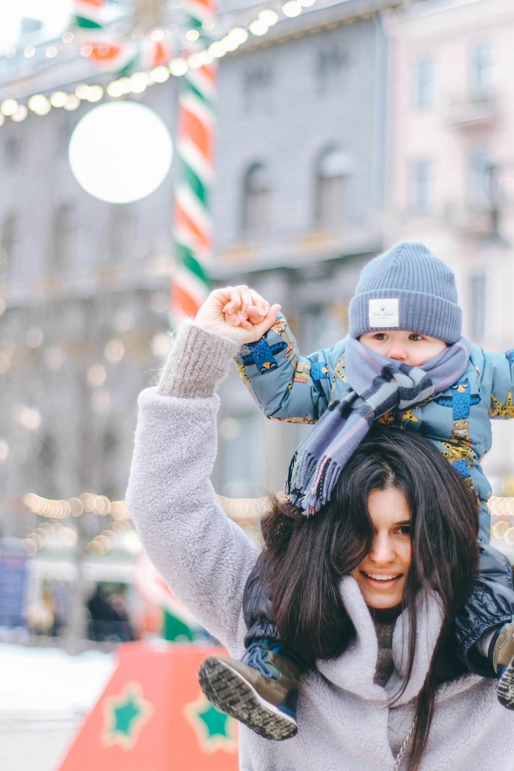 a woman holding a child on her shoulders