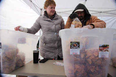 Volunteers warmly handing out meals to people in need on a chilly evening.