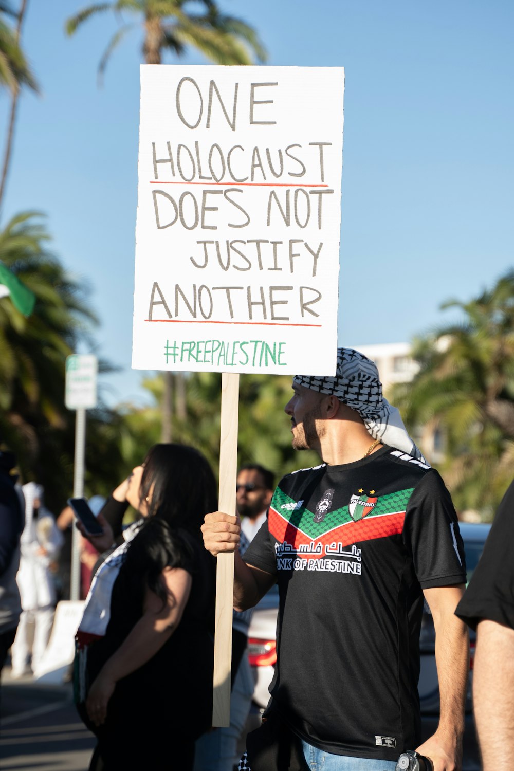 a man holding a sign that says one holocaust does not justicely