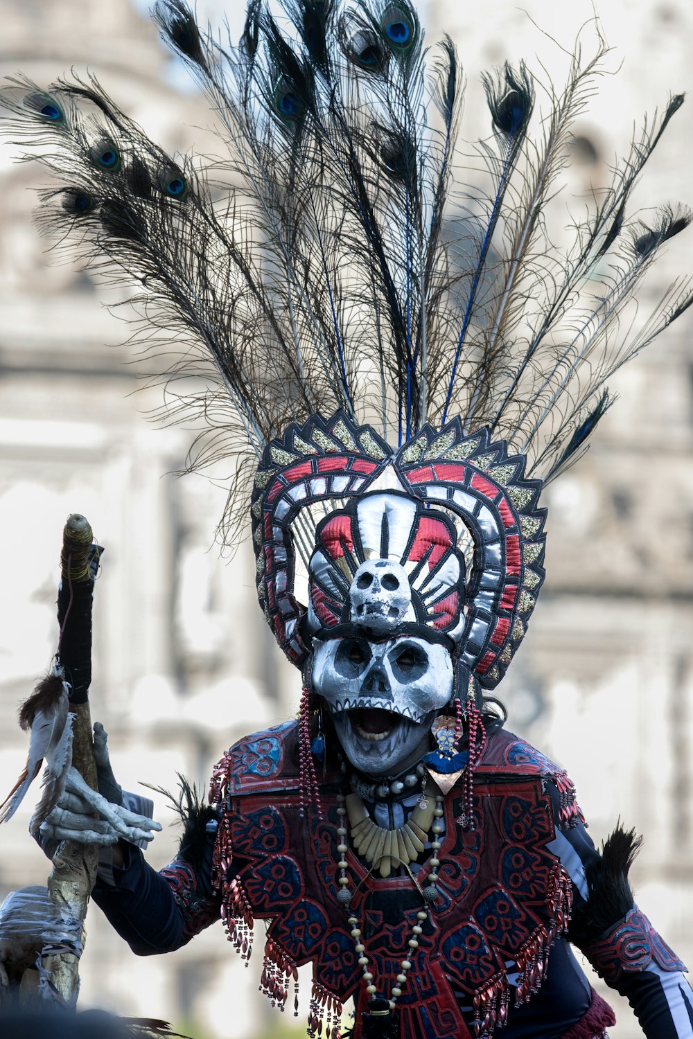 un homme portant un masque avec des plumes sur la tête