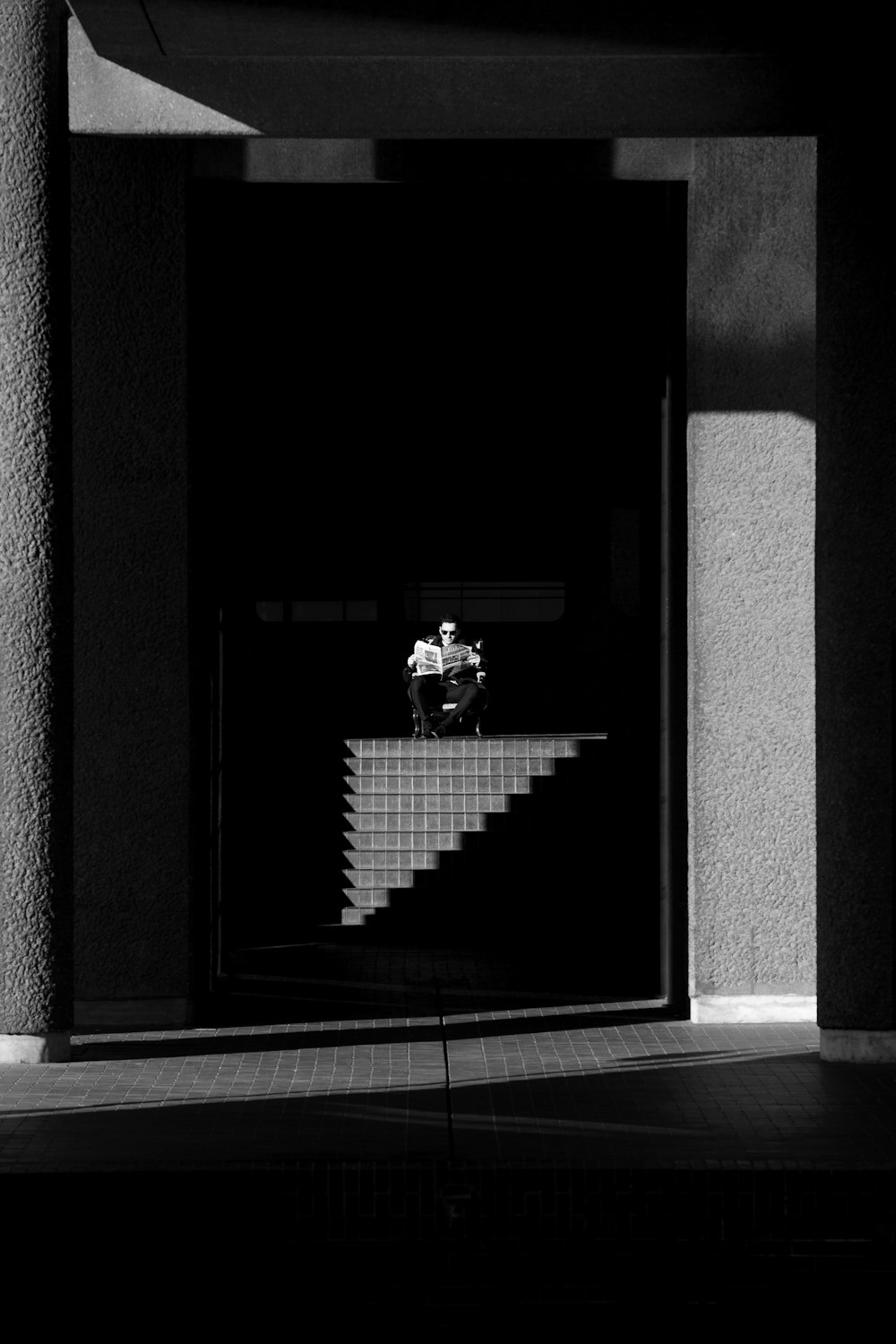 a black and white photo of a person sitting on a bench