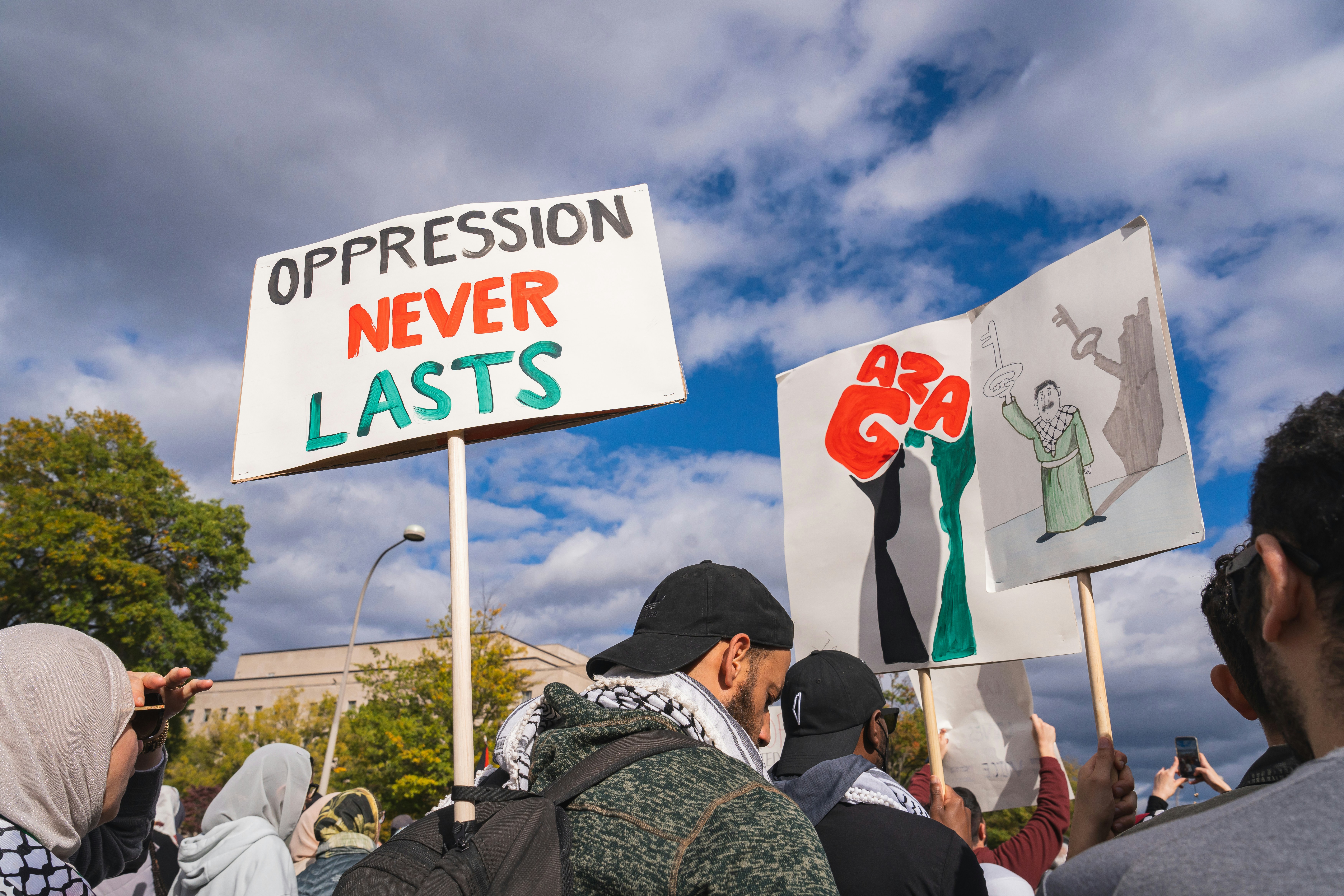 a group of people holding signs in front of a building