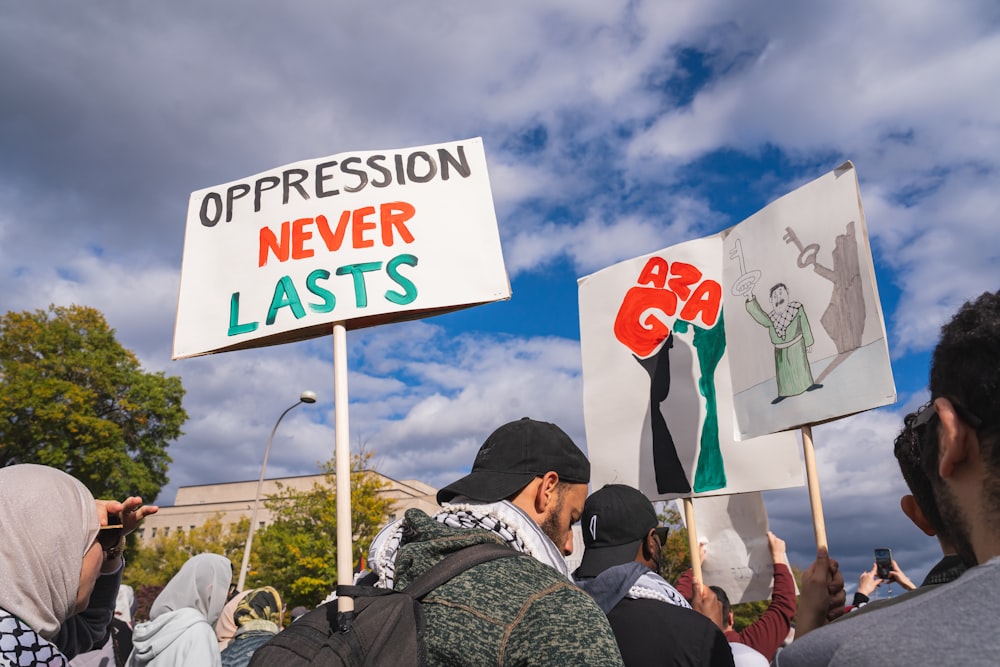 a group of people holding signs in front of a building