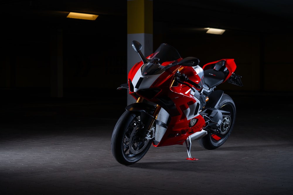 a red motorcycle parked in a parking garage