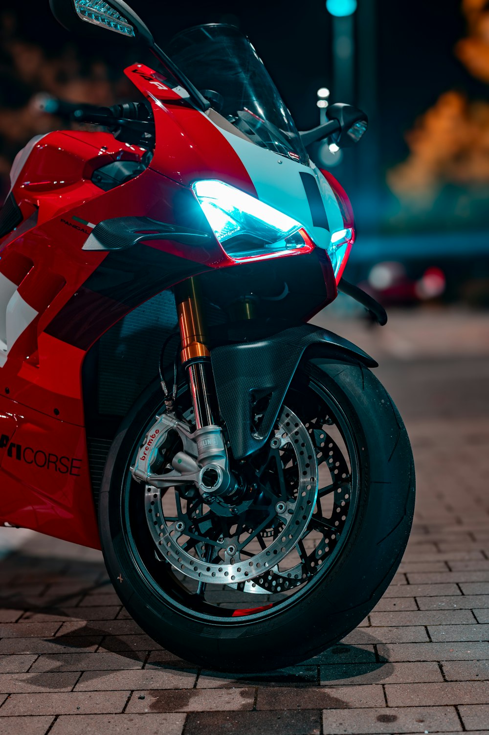 a red motorcycle parked on a brick road