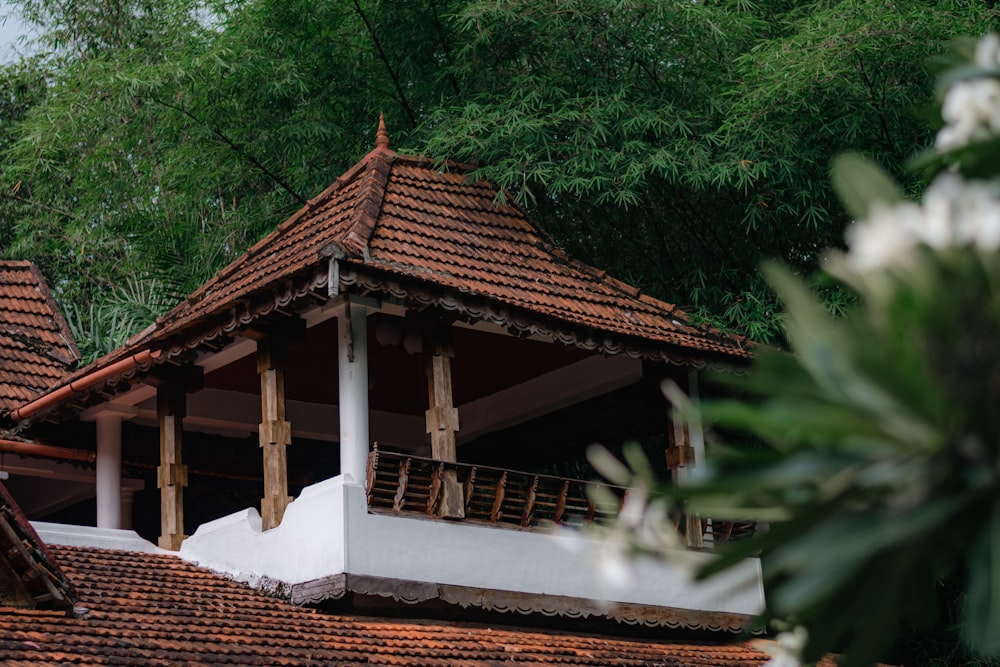 a white and brown building with a red roof