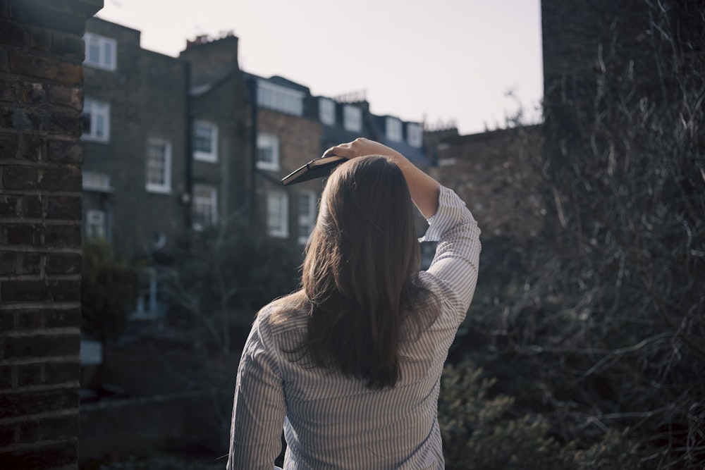 a woman standing in front of a brick building