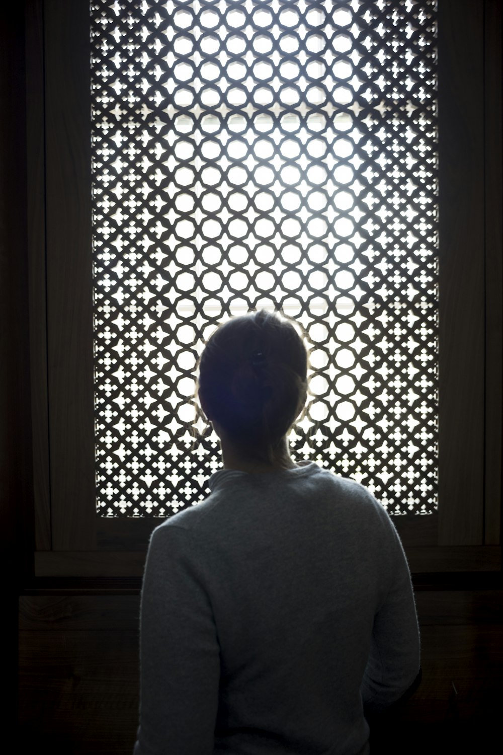 a person standing in front of a window with circles on it