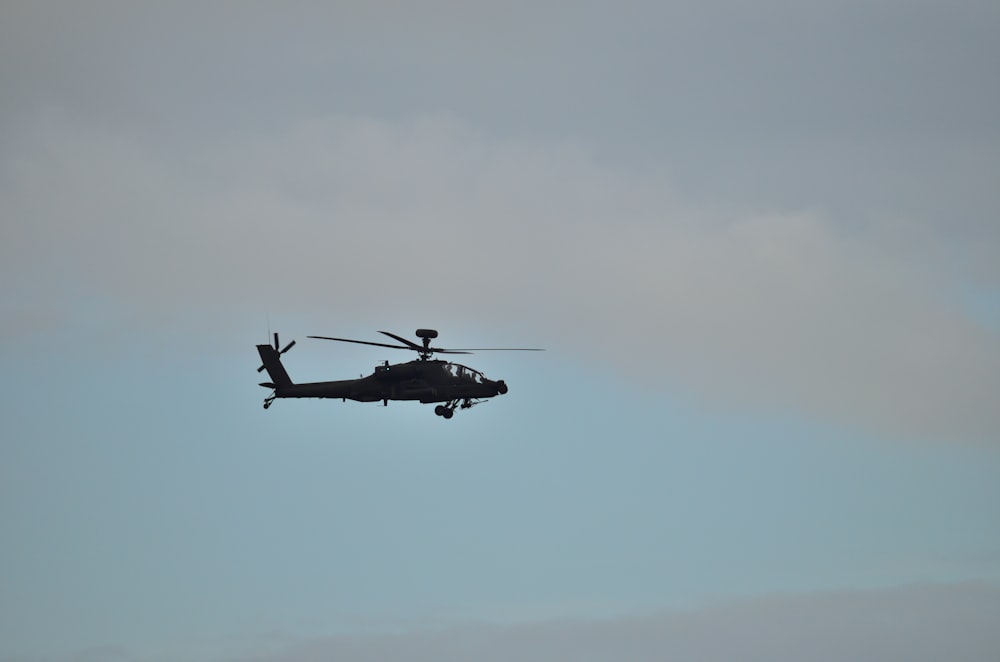 a helicopter flying in the sky on a cloudy day