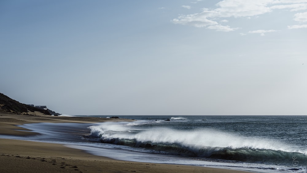 a large body of water sitting next to a sandy beach