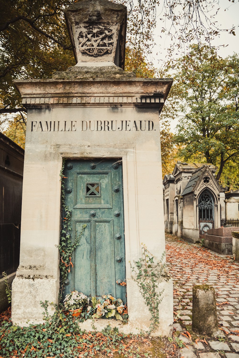 an old cemetery with a blue door surrounded by leaves