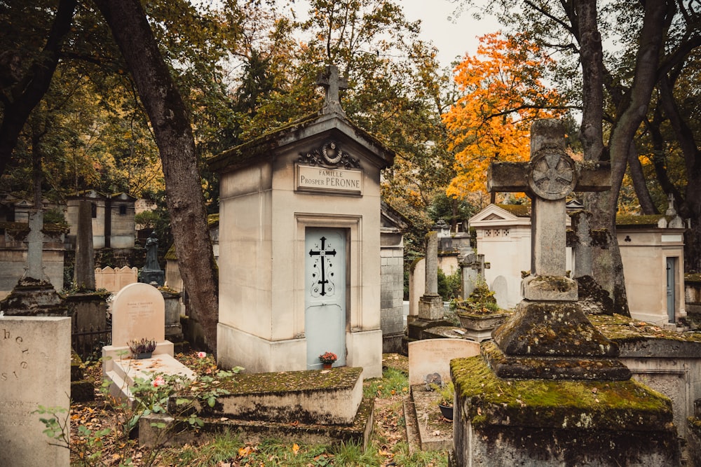 ein Friedhof mit einer blauen Tür, umgeben von Bäumen