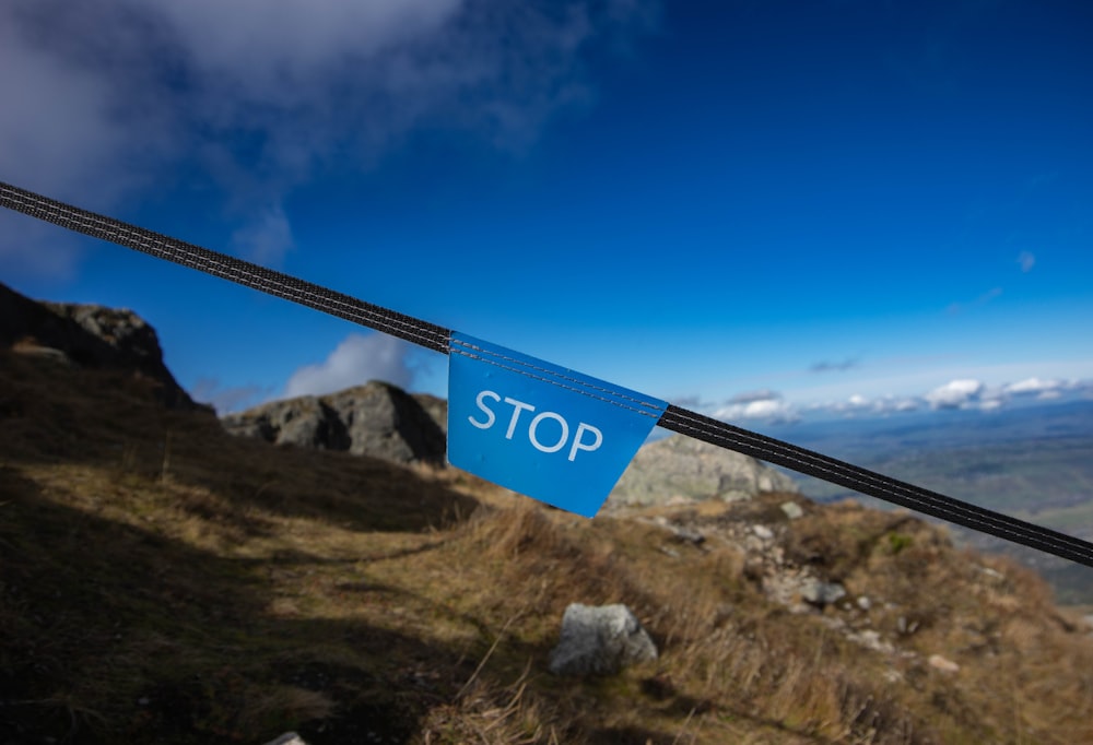 a blue sign is hanging on a rope