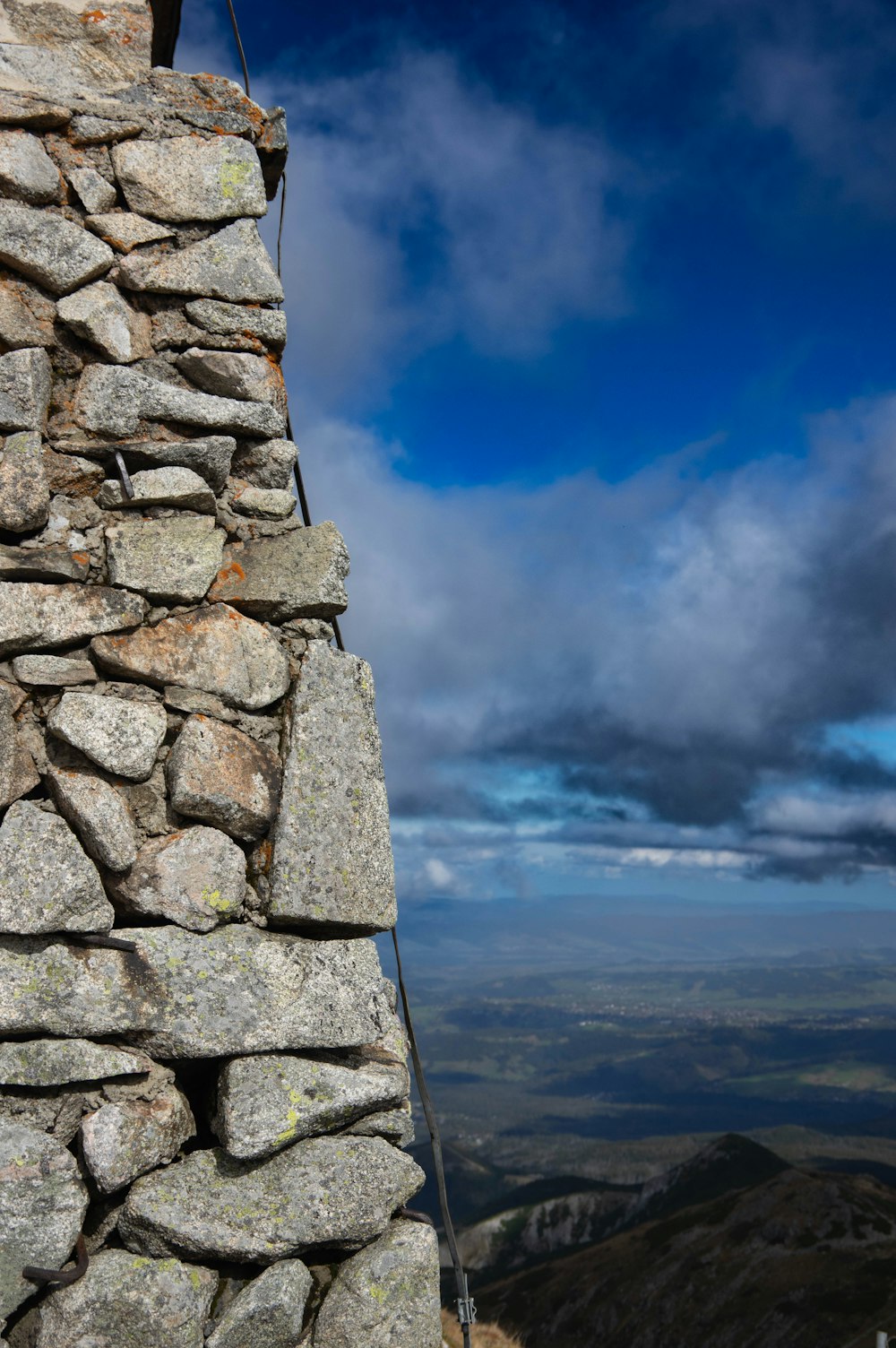 a stone wall with a sky in the background