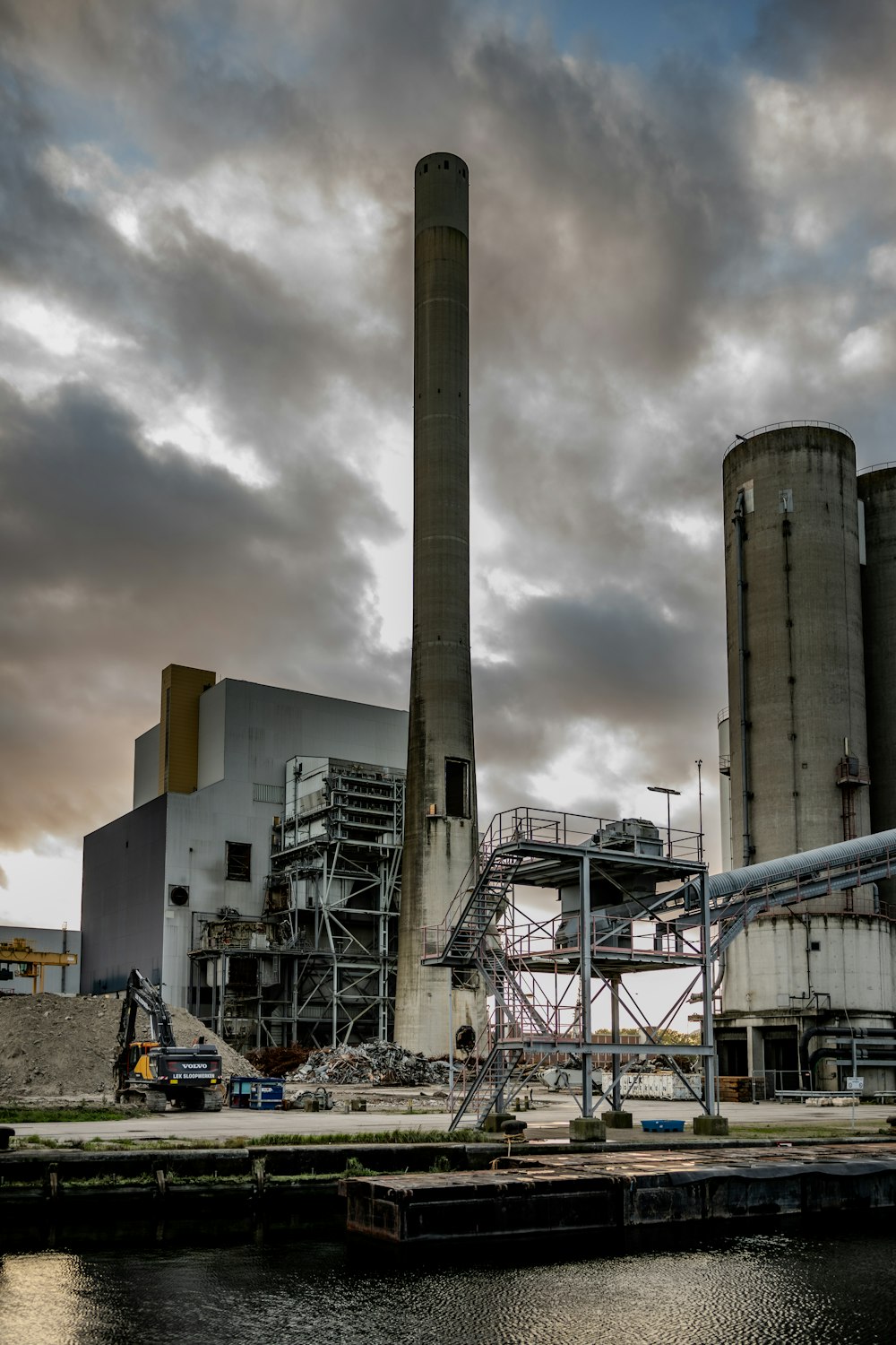 a factory with smoke stacks on a cloudy day