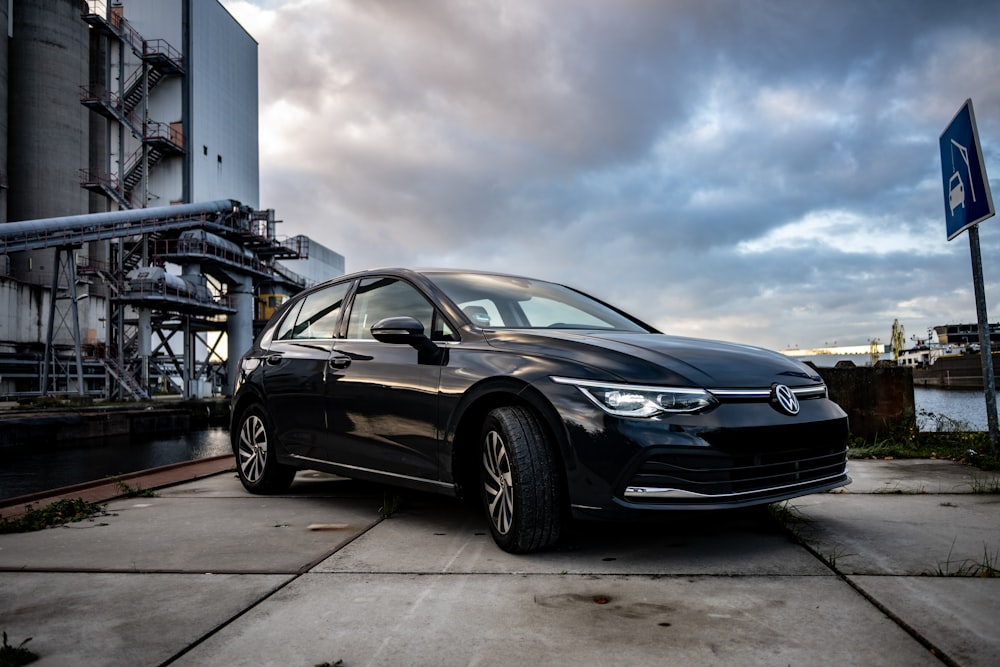 a black car parked in front of a factory